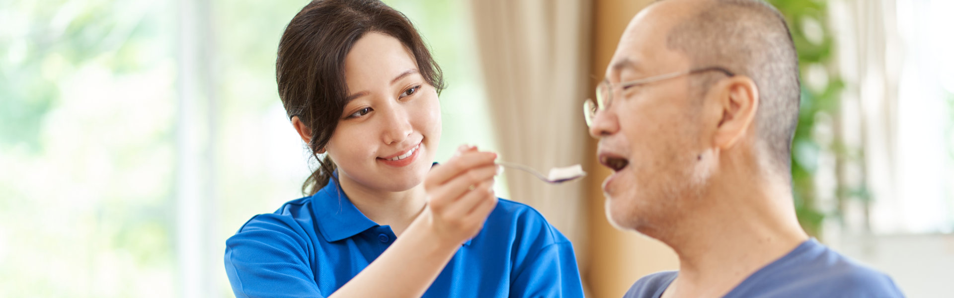 caregiver feeding elderly